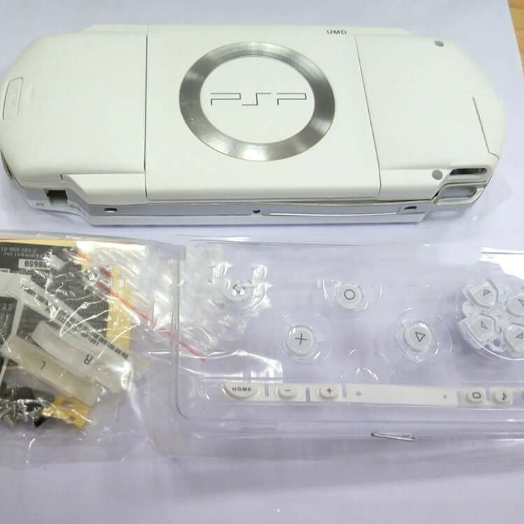 Psp1000 handheld computer protection housing in white color with buttons and accessories displayed.