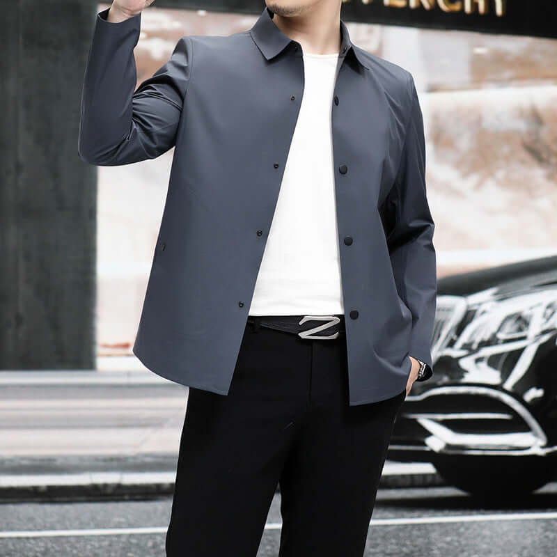 Man wearing a stylish gray seamless jacket, paired with a white t-shirt and black pants, showcasing a modern urban look.