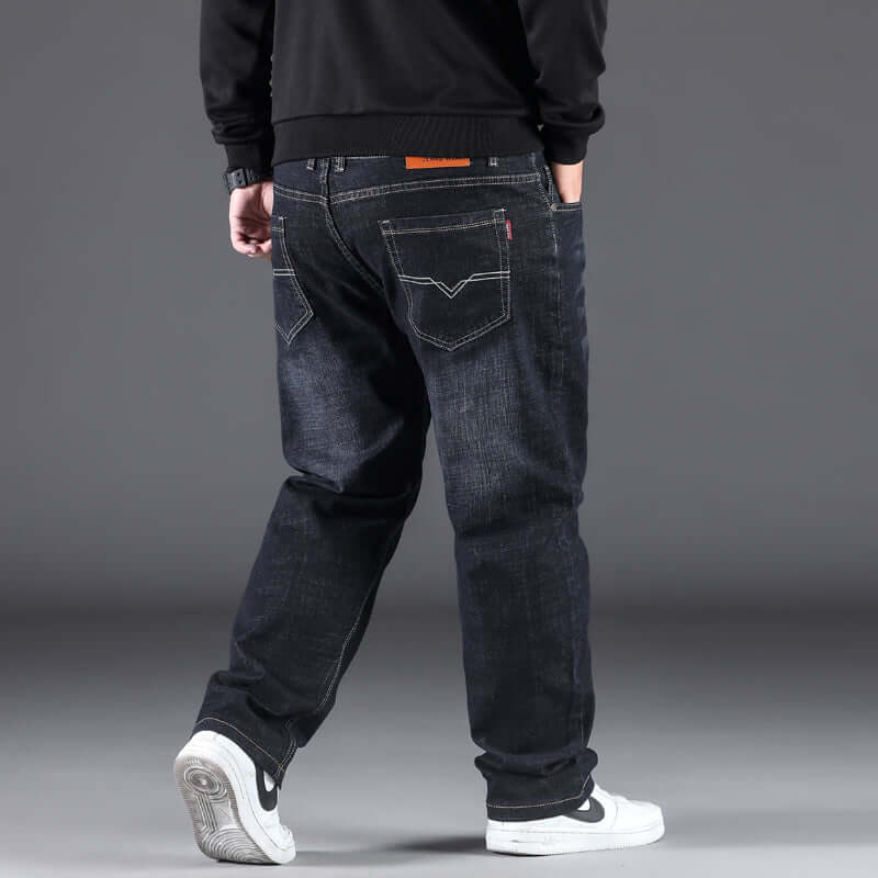 Men's fashion casual straight loose-fitting pants in dark denim, worn with a black sweatshirt and white sneakers.
