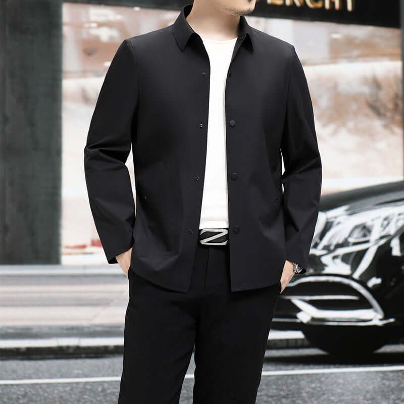 Slim fit black jacket on a man, paired with a white t-shirt and casual pants, stylish urban background.