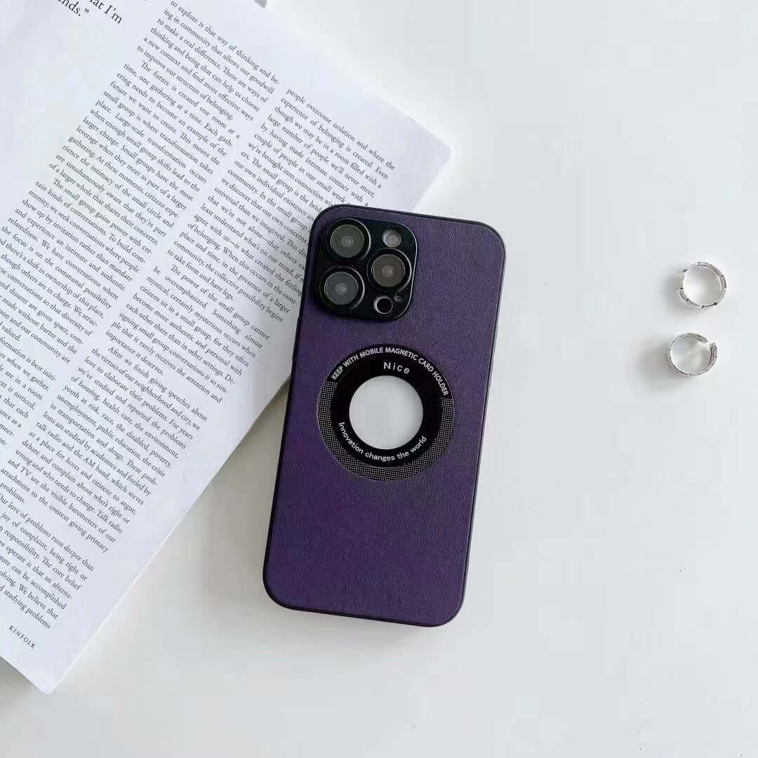 Purple imitation leather phone case with magnetic feature, showcasing embossed design on a table with books and jewelry.