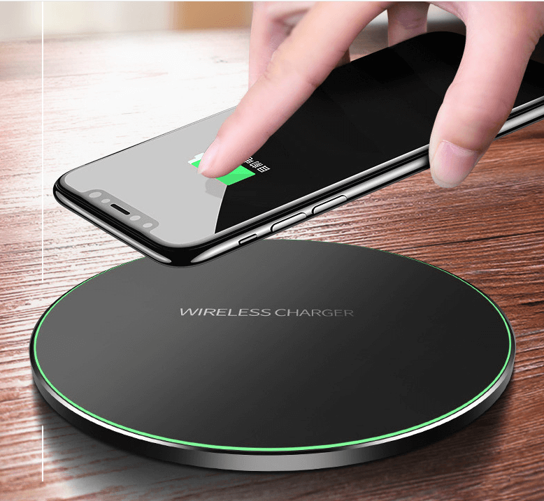 Hand placing smartphone on a wireless charger, indicating fast charging with a green light.
