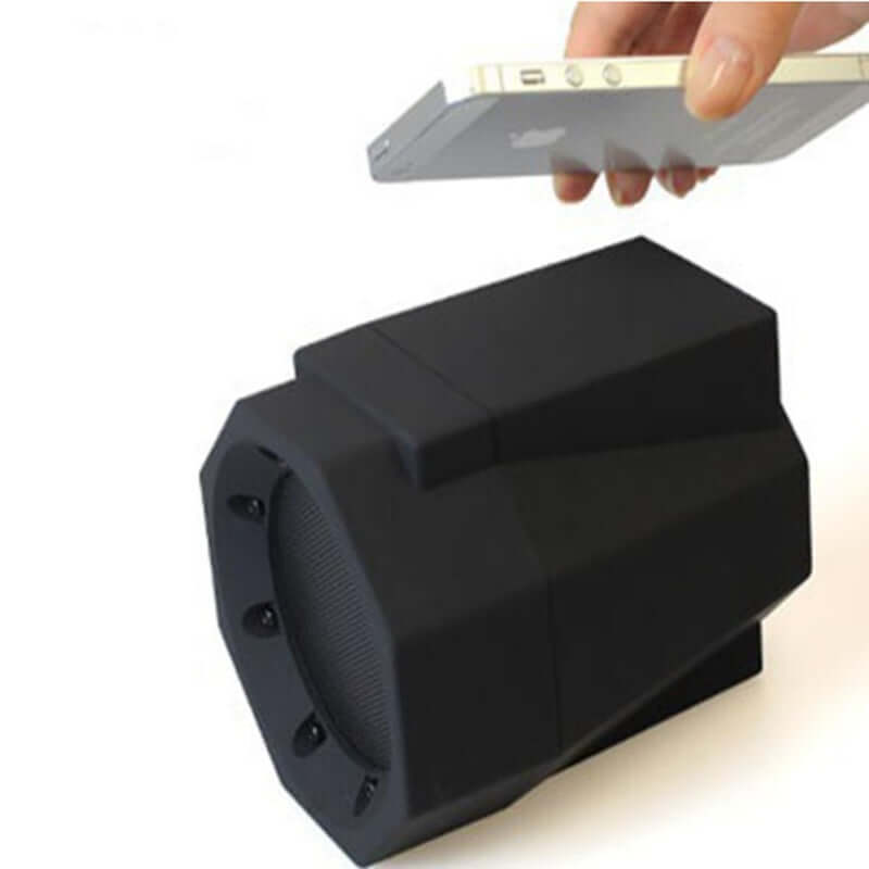 Smart magnetic induction resonance speaker with smartphone in use for audio playback.