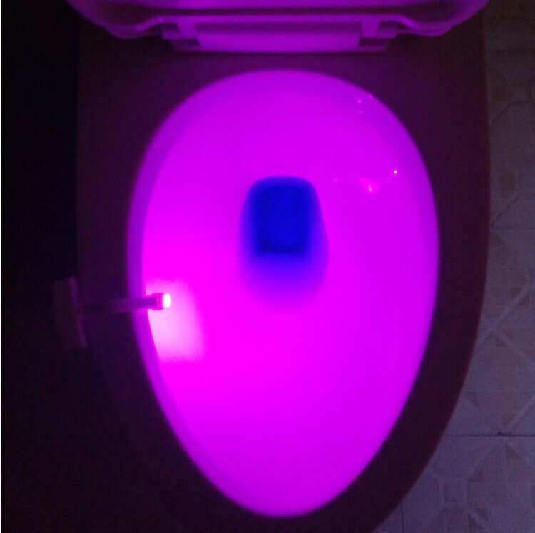 Toilet with pink LED night light illuminated, showcasing motion-sensing technology for added convenience.