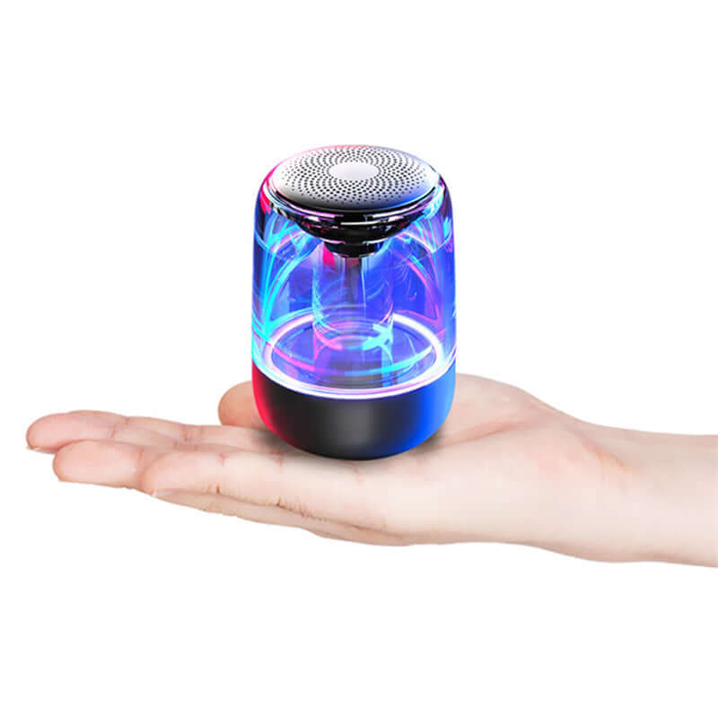Portable Bluetooth speaker with LED lights, held in hand, powerful bass, perfect for outdoor use.