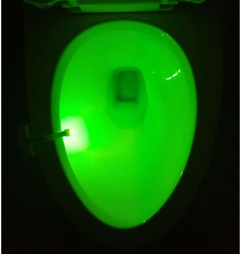 Green LED toilet night light illuminating the inside of a toilet bowl, showcasing modern motion sensor technology.