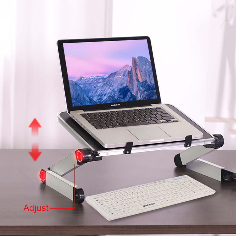 Foldable laptop stand with adjustable height, supporting a MacBook and keyboard on a desk for ergonomic use.