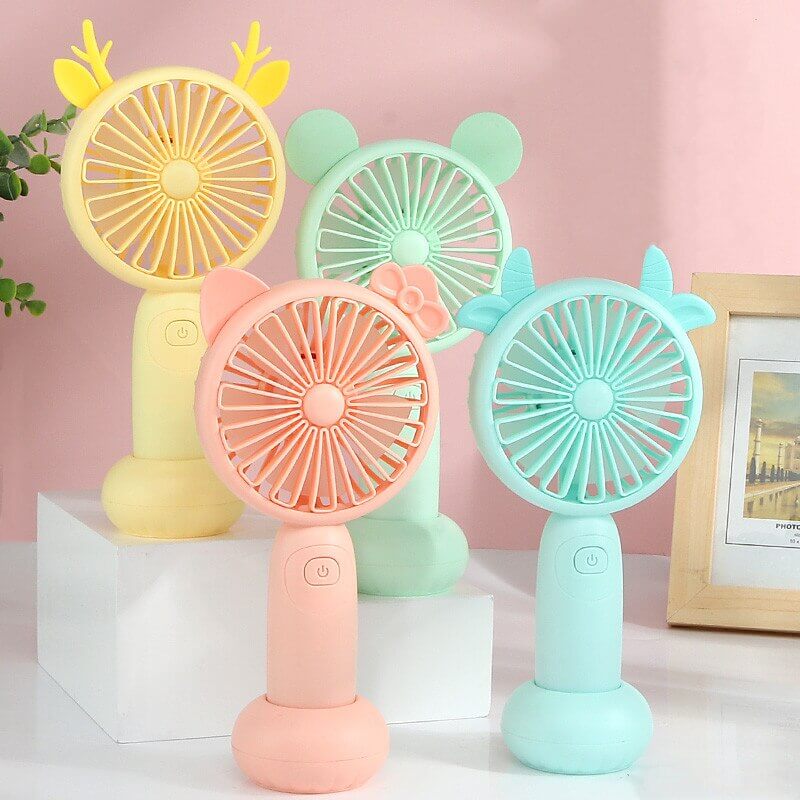 Colorful portable mini USB fans in pastel shades of yellow, pink, green, and blue, arranged attractively on a table.