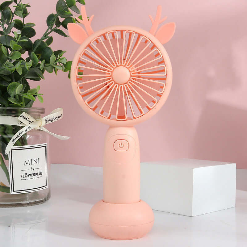 Mini portable electric fan in pink color with deer antlers design, perfect for on-the-go cooling.