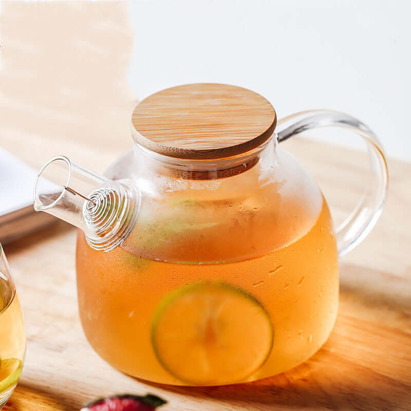 Nordic style transparent glass kettle with bamboo lid, perfect for tea or beverage serving.