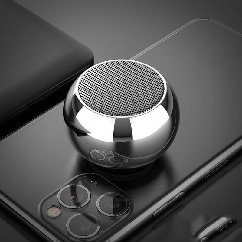 M3 colorful mini Bluetooth speaker in a chrome finish on top of a smartphone.