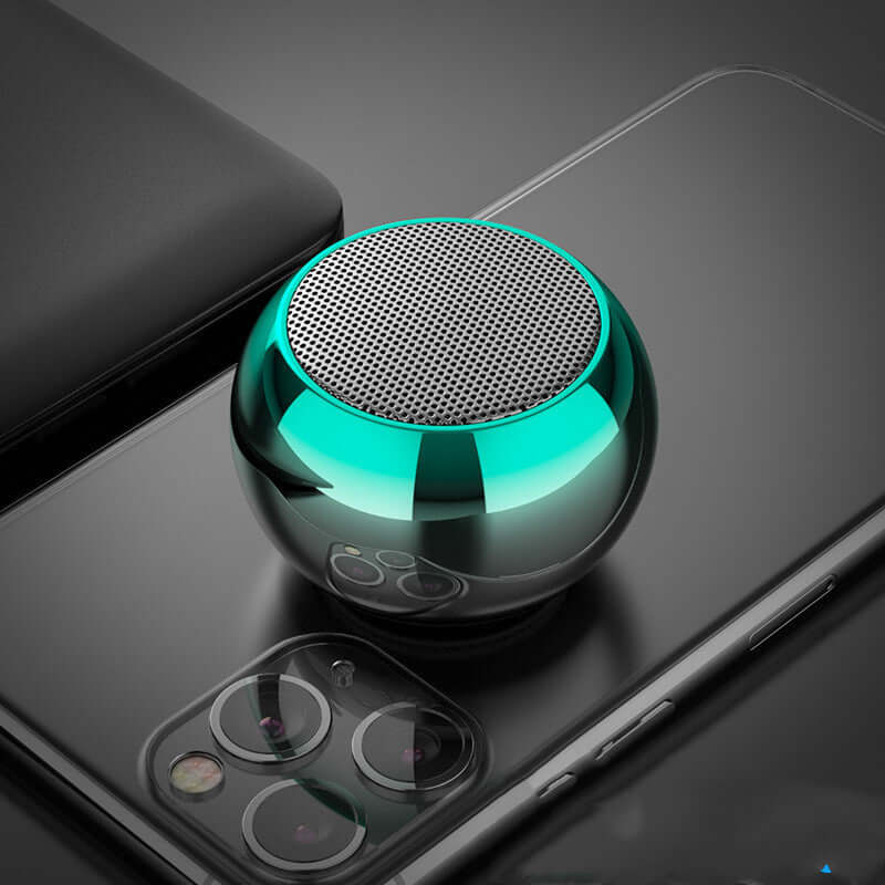 M3 colorful Bluetooth speaker in bright gradient color on a smartphone, showcasing its unique round design and sleek finish.