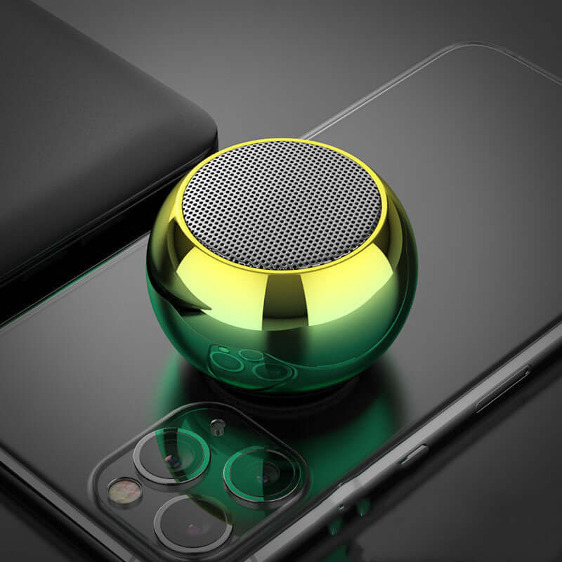 M3 Colorful Wireless Speaker in yellow-green gradient color placed on a smartphone, showcasing mini electroplating design.