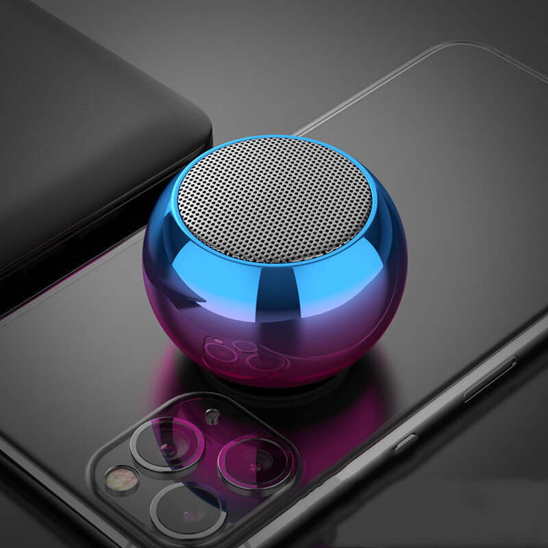 M3 colorful Bluetooth speaker in gradient blue and pink, placed on a smartphone, showcasing sleek design and modern aesthetics.