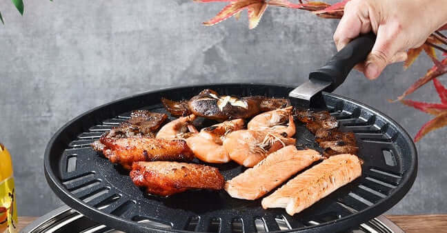 Delicious grilled seafood and meat on a Korean stainless steel charcoal barbecue grill, ready for serving.