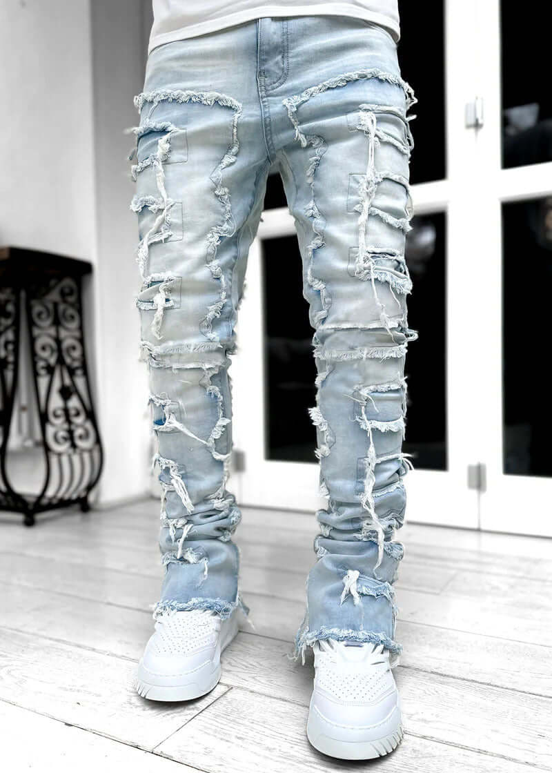 Men's ripped light blue stacked jeans with unique patched design, stylish and comfortable for casual wear.