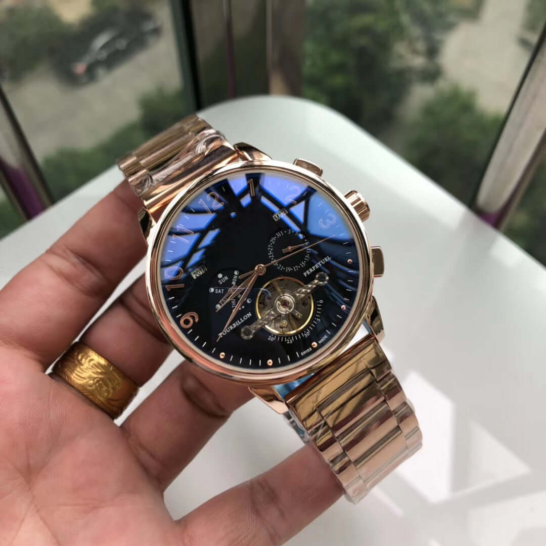 Big flywheel mechanical watch with stainless steel strap and intricate black dial, showcasing calendar and small three needles.
