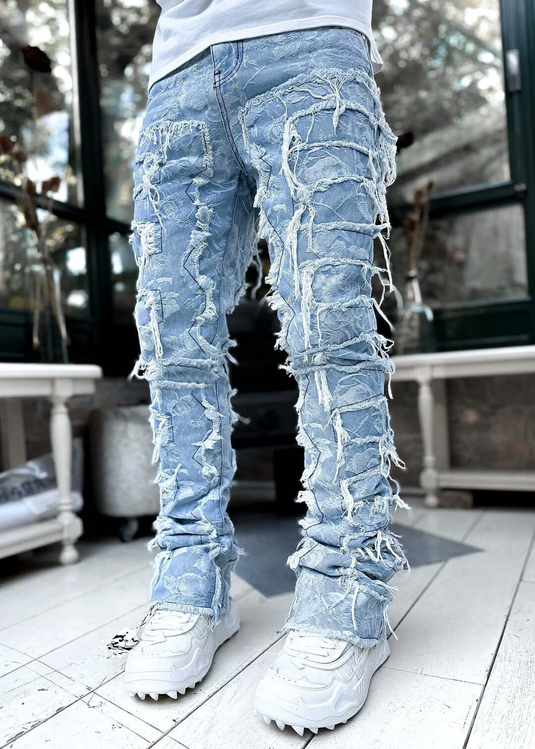 Men's long tight fit stacked jeans in light blue with unique ripped design, perfect for a fashionable look.
