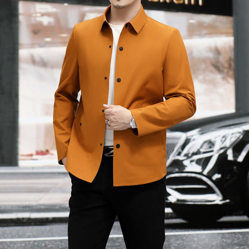 Stylish man wearing a slim-fit orange jacket, complementing urban surroundings.