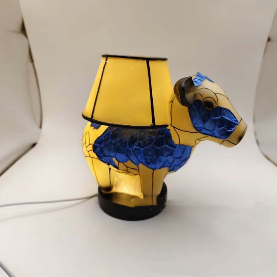 Vintage cow table lamp in vibrant blue and yellow with fabric shade, ideal for bedroom or living room decor.