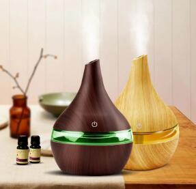 Wood grain tip humidifier air purifier in light and deep wood finishes, enhancing home ambiance with essential oils.