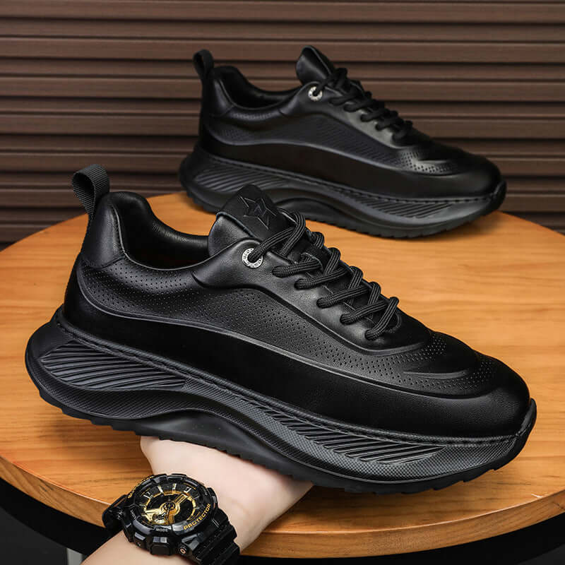 Men's thick-soled black sports shoes with breathable design and lace-up closure on wooden surface.