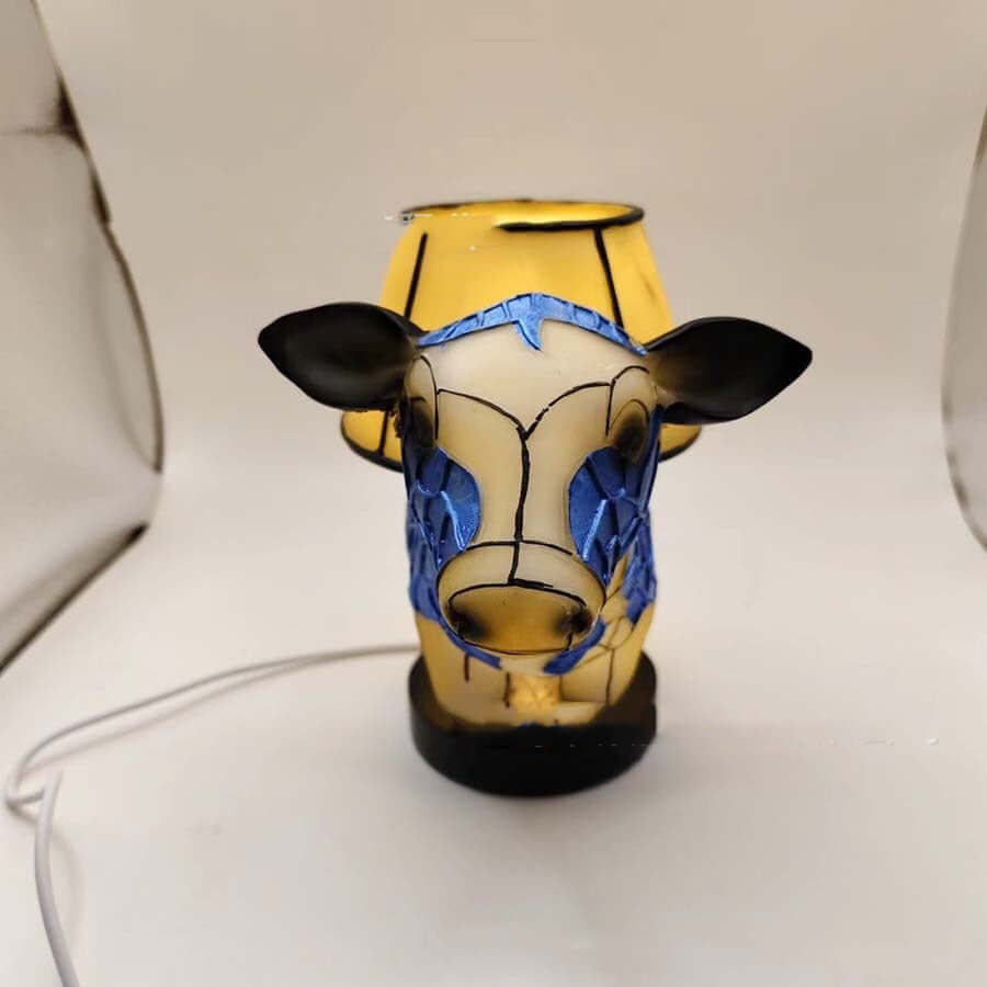 Vintage cow table lamp with blue and yellow design, ideal for bedside or home decor.