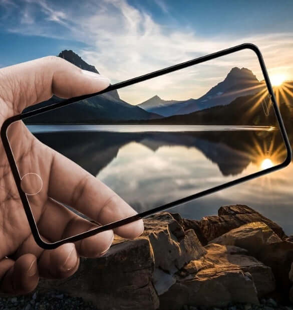 Hand holding a phone case against a scenic mountain landscape with a lake at sunset.