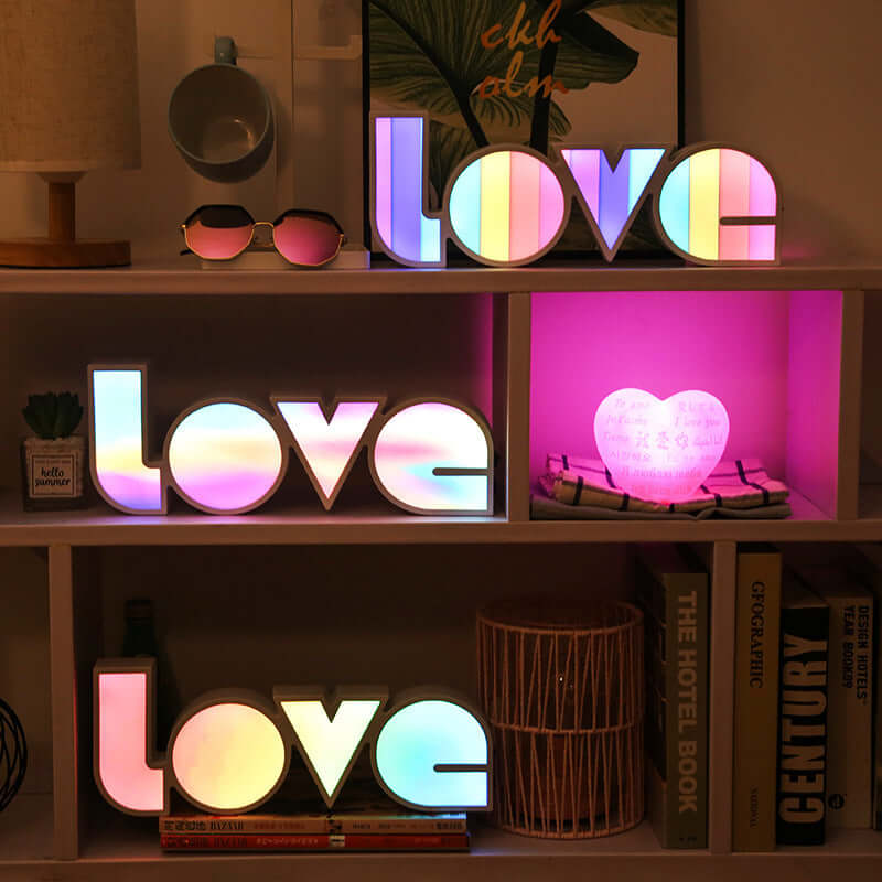 Colorful LED LOVE decorative lights displayed on shelves, perfect for holiday decorations and home ambiance.