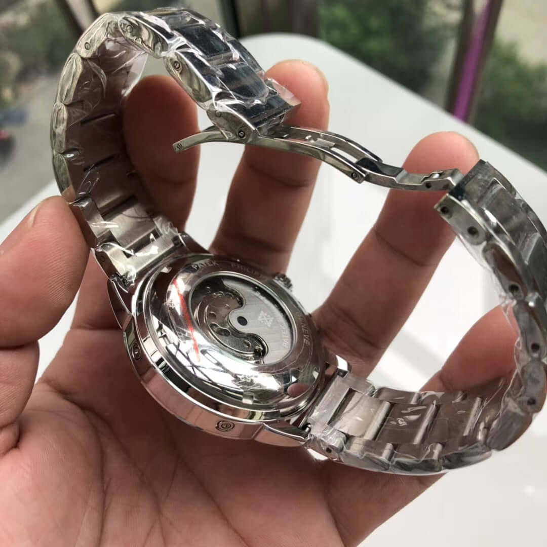 Big flywheel mechanical watch showcasing stainless steel back and butterfly buckle, held in hand for scale.
