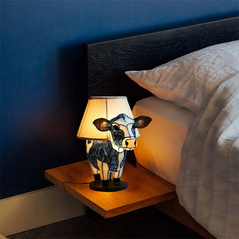 Charming cow table lamp with USB, perfect for bedside decor in a bedroom or dormitory setting.