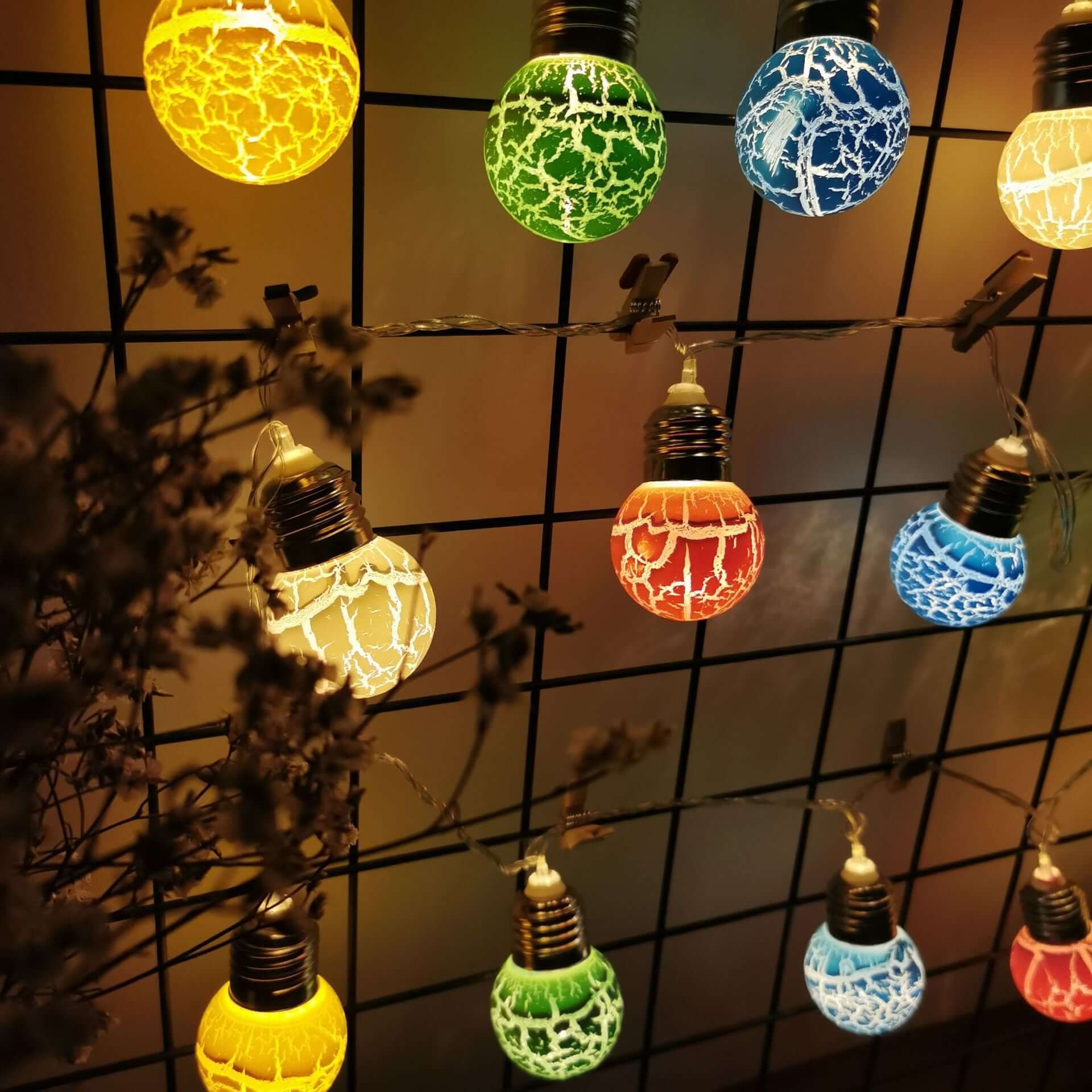 Colorful LED crackle bulb string lights on a decorative wall for festive celebrations.