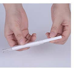 Person holding a white pen on a plain background, demonstrating its sleek design and portability.