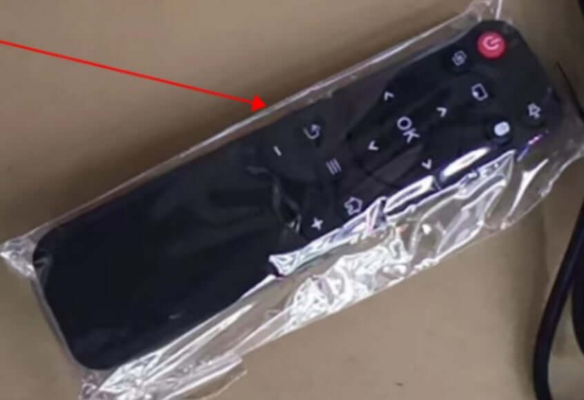 Remote control for portable projector, enclosed in protective plastic packaging.
