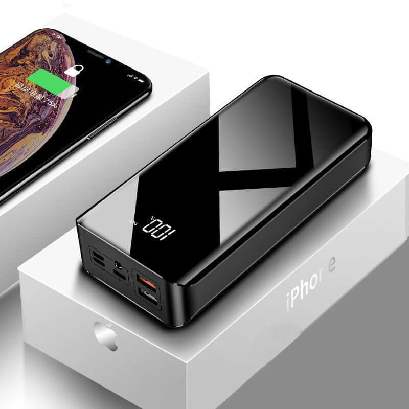 30000mAh power bank with LCD display, placed next to an iPhone with charging indicator, showcasing sleek design and functionality.