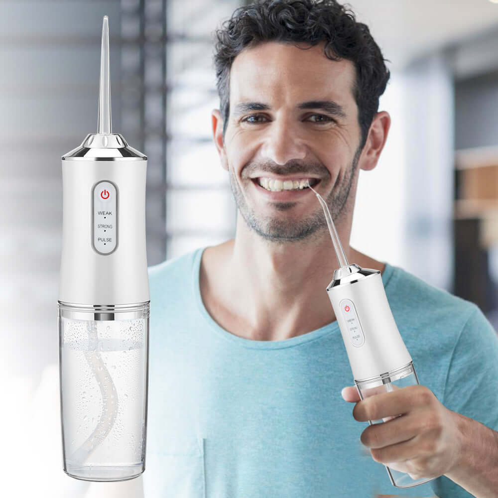 Man smiling while holding a household 3-speed hand-held electric dental irrigator, showcasing its sleek design.