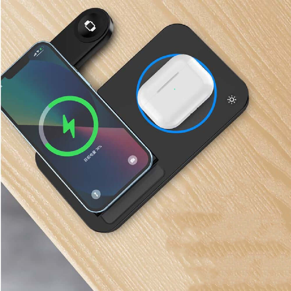 Folding three-in-one wireless charging stand with smartphone and charging AirPods on a wooden surface.