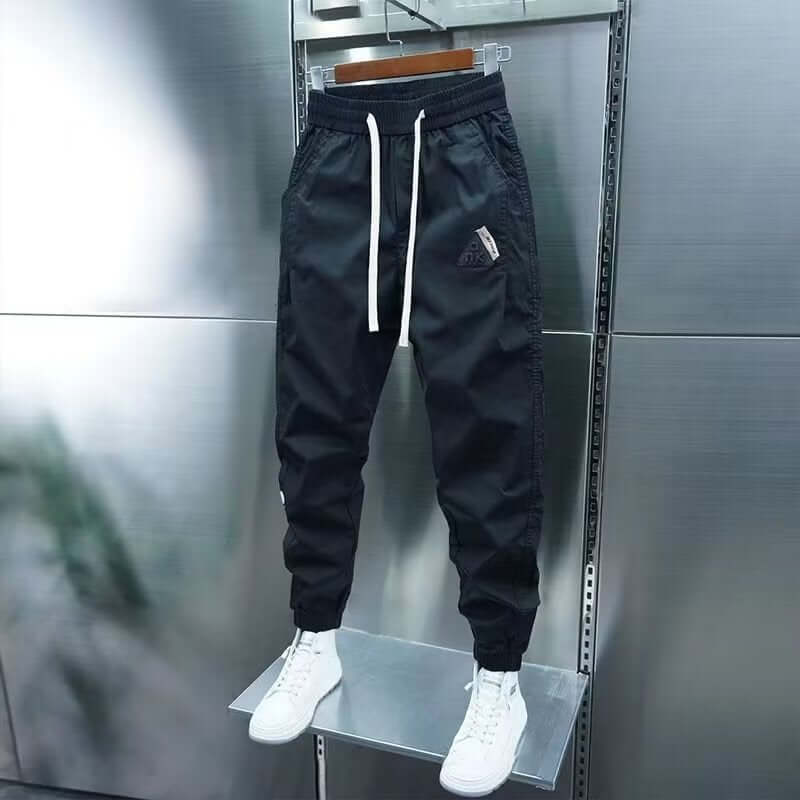 Men's black ankle banded jogger pants with drawstring, solid color, suitable for leisure activities.