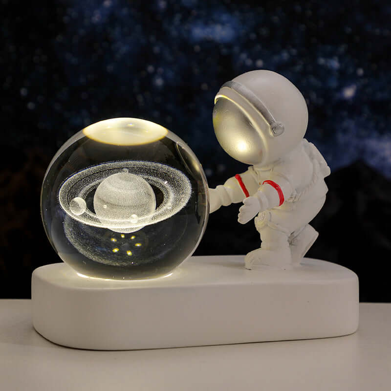 Astronaut holding a glowing crystal ball with a planet design, perfect for bedside lighting and romantic atmospheres.