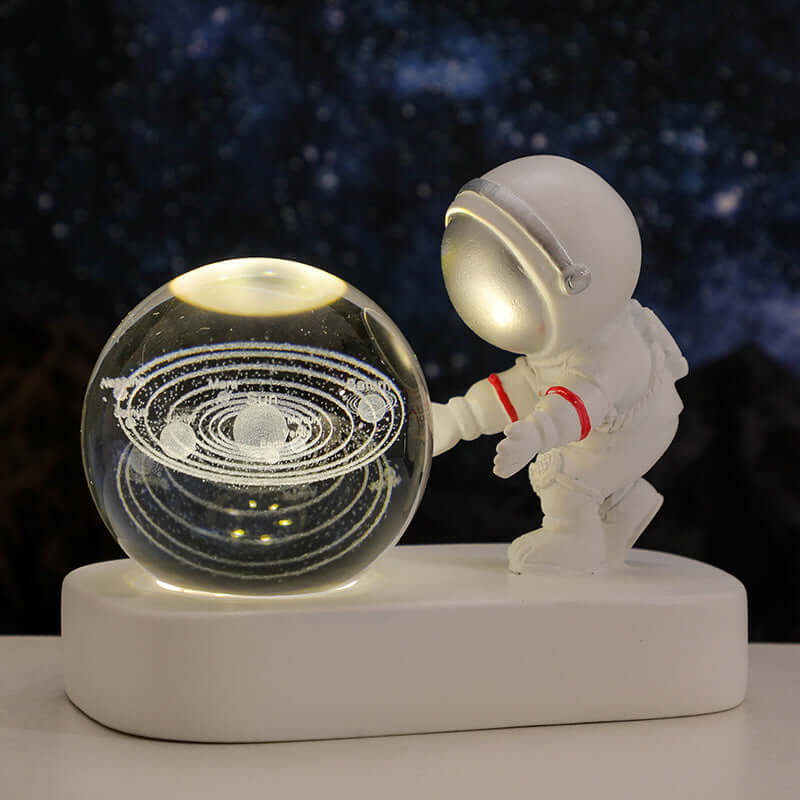 Astronaut figurine with a crystal galaxy ball night light on a base, creating a warm, cosmic ambiance for bedrooms.