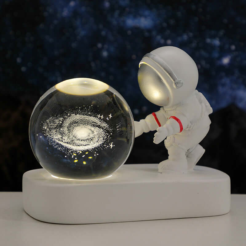 Astronaut figurine beside a glowing crystal ball with galaxy design, perfect for bedside night light ambiance.