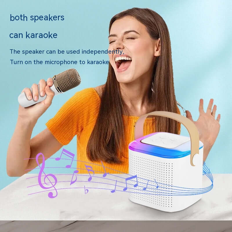 Woman singing with a microphone beside a portable karaoke speaker, enjoying a fun music experience.