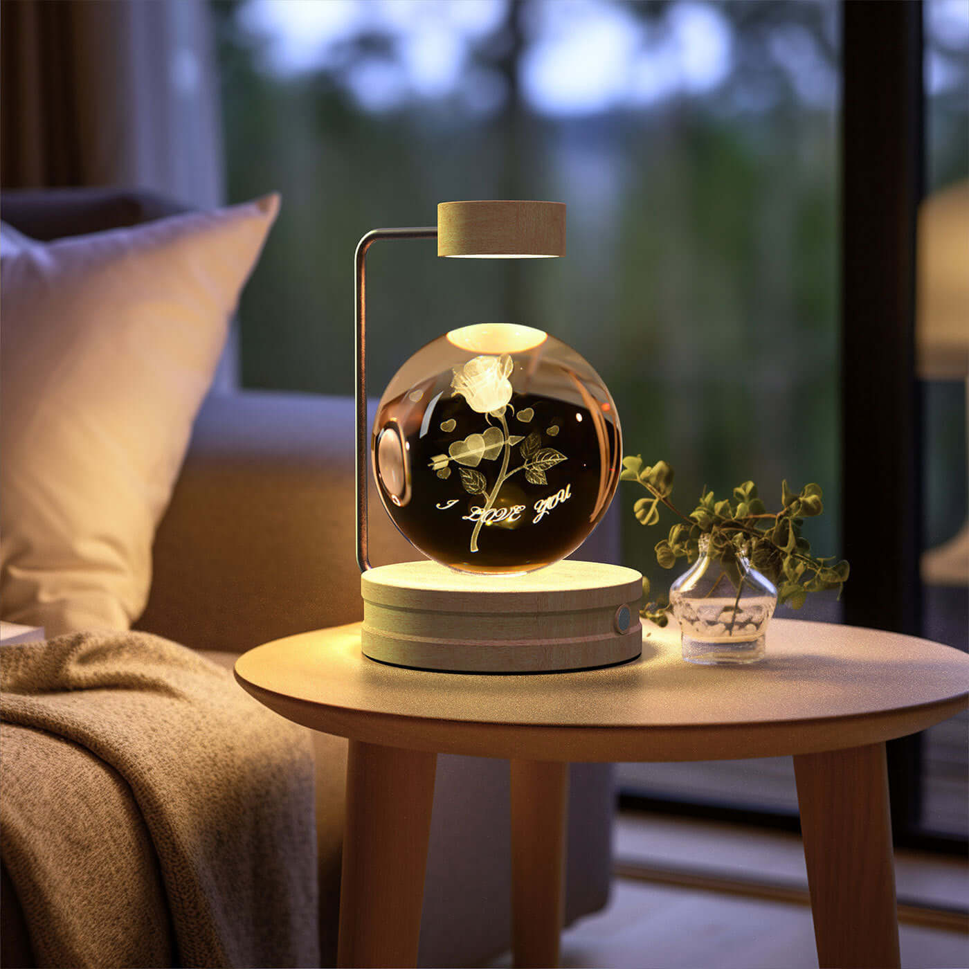 Crystal ball night light with a rose design, creating a warm ambiance on a bedside table.