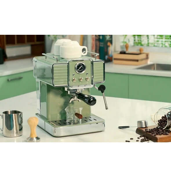 Vintage green 15 bar espresso coffee machine with milk frother, set on kitchen counter with coffee accessories.