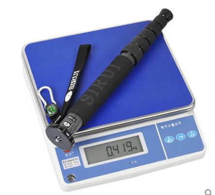 Carbon fiber monopod on a digital scale, showcasing weight for portable travel photography gear.
