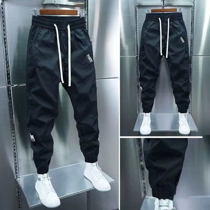 Black cropped leisure pants for men, featuring a drawstring waist and ankle cuffs, perfect for summer wear.