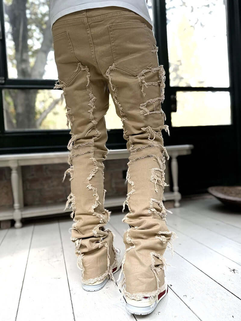 Men's long ripped light brown stacked jeans showcasing unique distressed design and tight fit style.