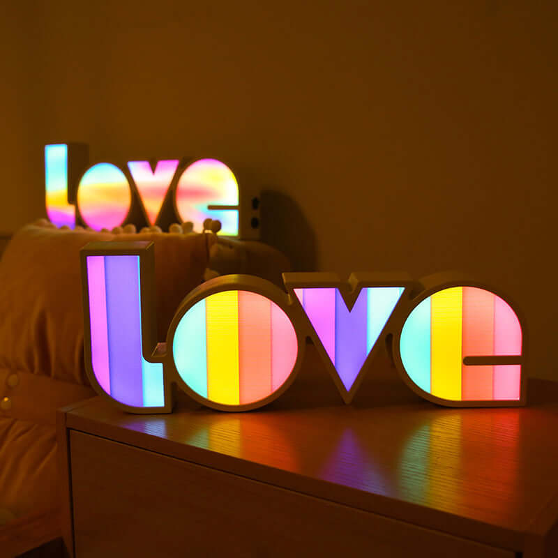 Colorful LED 'LOVE' decorative lights on a shelf, perfect for holiday ambiance and home decor.