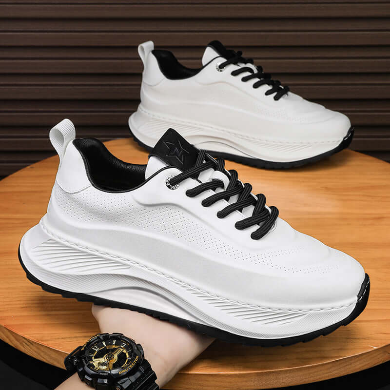 Men's thick-soled white sports sneakers with lace-up design on a wooden surface. Casual and stylish footwear for everyday wear.