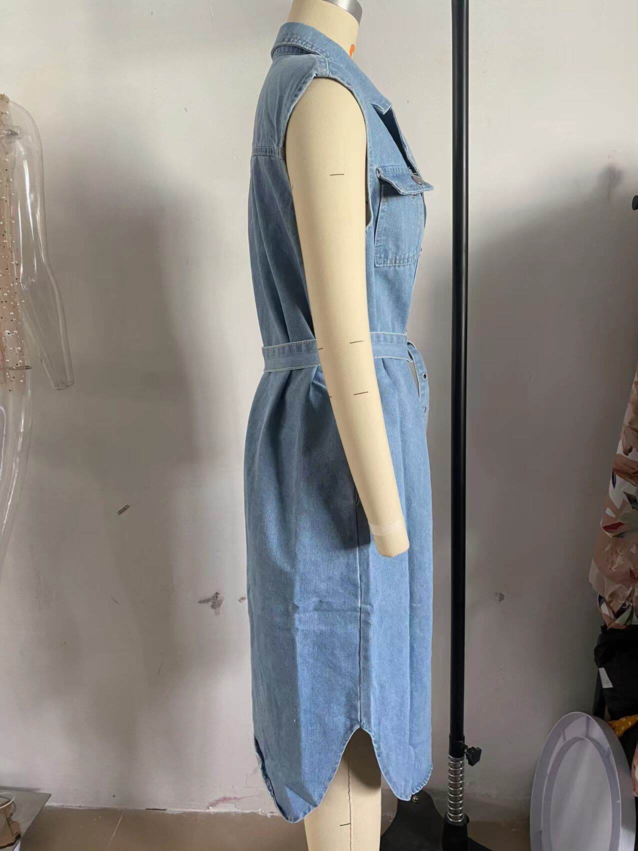 Light blue denim sleeveless dress with polo collar and cinched waist on a mannequin.
